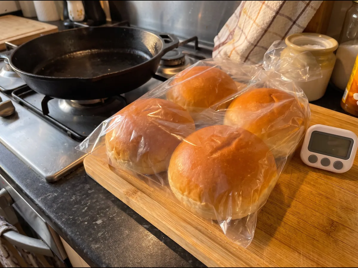 Pães de hambúrguer brioche a descongelar dentro do seu saco na bancada
